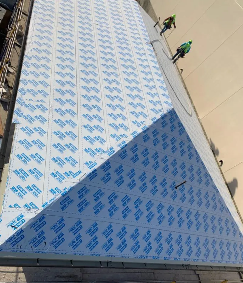 Professional roofers installing underlayment on a metal roof in Phoenix
